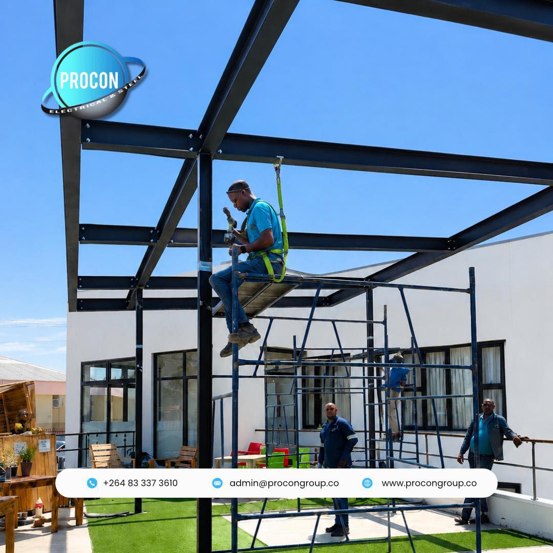 Steel pergola installation outside building with worker in safety harness